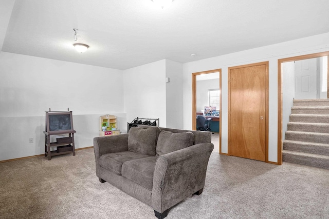 living room featuring baseboards, stairs, and carpet