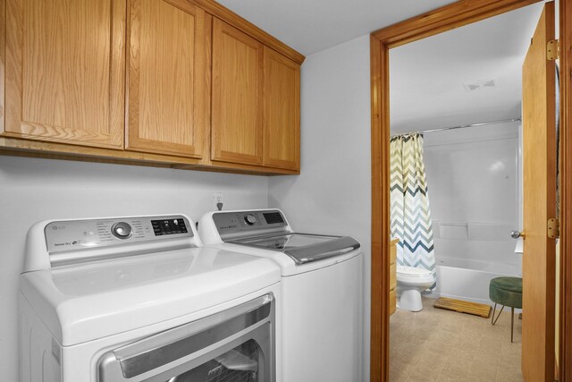 laundry area featuring visible vents, cabinet space, light floors, and washer and clothes dryer