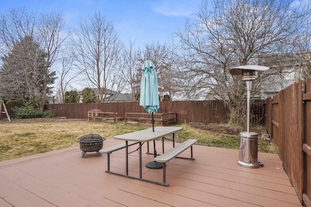 wooden deck with a yard, a fire pit, and a fenced backyard