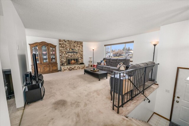 carpeted living room with a stone fireplace and a textured ceiling