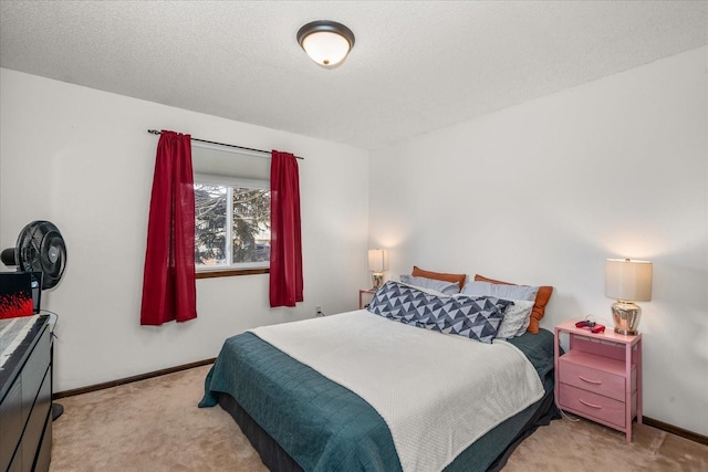 bedroom with light colored carpet, baseboards, and a textured ceiling