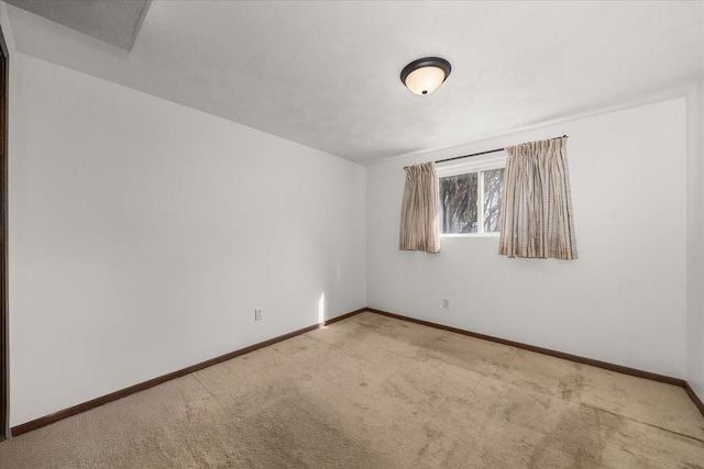 empty room with baseboards and carpet