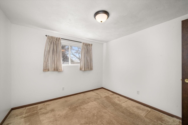 empty room with light colored carpet and baseboards