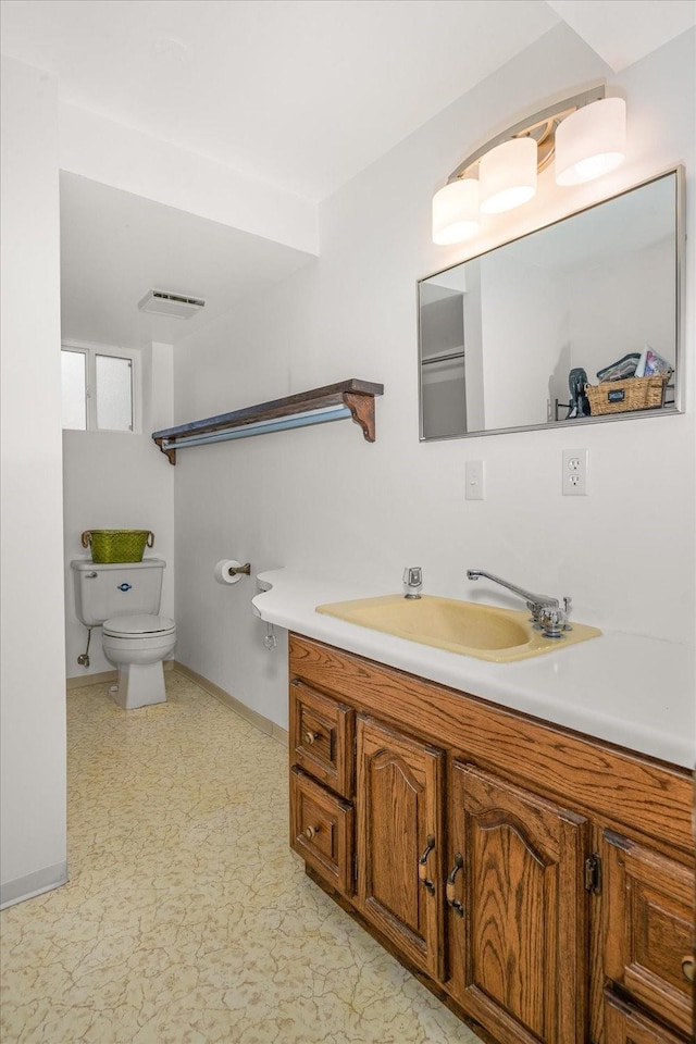 bathroom with visible vents, toilet, vanity, and baseboards