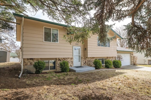 raised ranch featuring concrete driveway and an attached garage