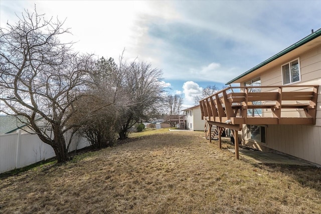 view of yard featuring a deck, stairs, and fence