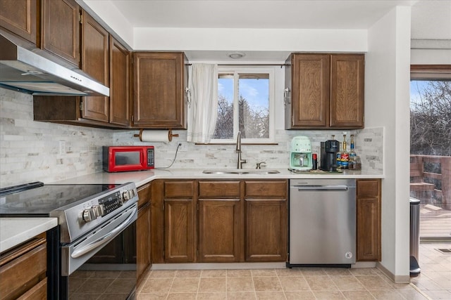 kitchen featuring a sink, plenty of natural light, under cabinet range hood, and stainless steel appliances