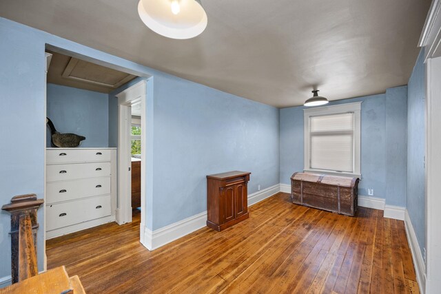 interior space featuring attic access, baseboards, and wood-type flooring