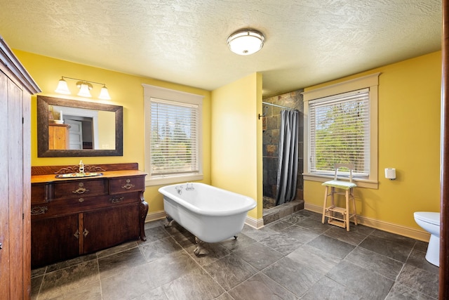 bathroom featuring a freestanding tub, baseboards, a stall shower, and vanity