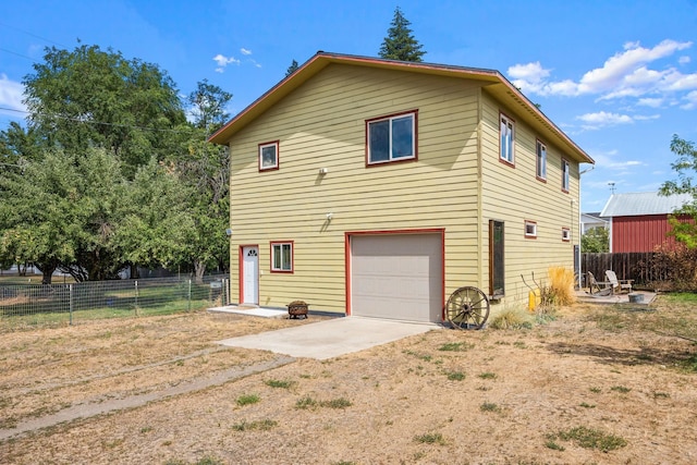 rear view of property featuring fence and dirt driveway