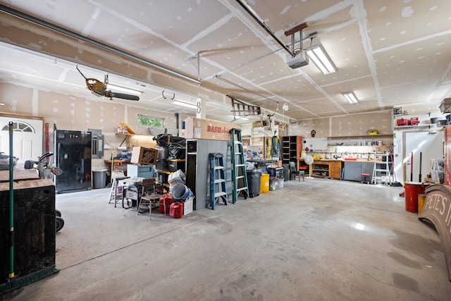 garage featuring a workshop area, electric panel, and a garage door opener