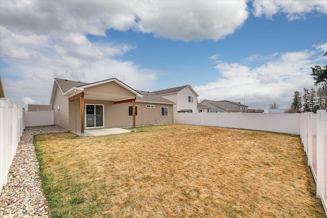 rear view of house with a patio, a lawn, and a fenced backyard