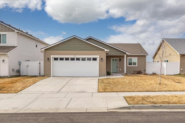 view of front of home with a front lawn, a gate, fence, concrete driveway, and a garage