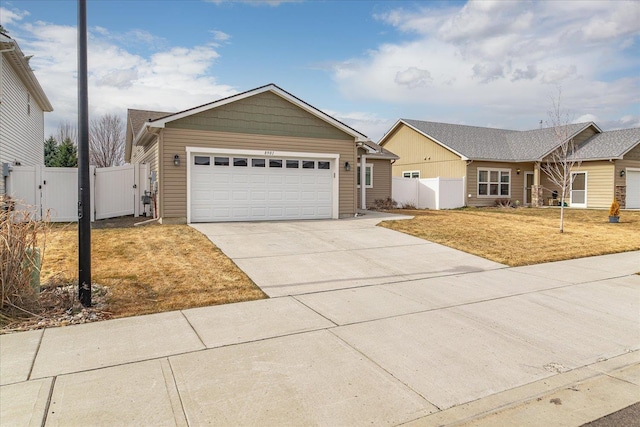 view of front of property with driveway, an attached garage, fence, and a gate