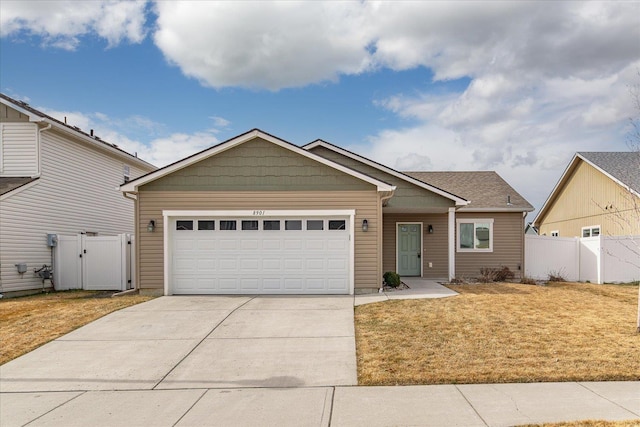 view of front of house with an attached garage, fence, a front yard, driveway, and a gate