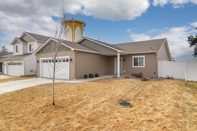 view of front of property with a front yard, fence, an attached garage, a shingled roof, and concrete driveway