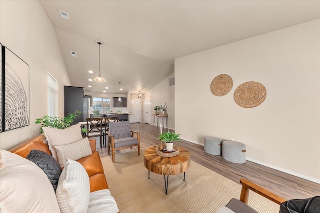 living room with visible vents, high vaulted ceiling, light wood-type flooring, and baseboards