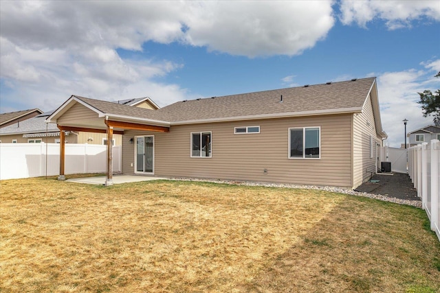 back of house with a patio, cooling unit, roof with shingles, a yard, and a fenced backyard