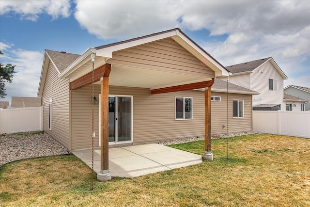 rear view of house featuring a yard, a patio, and a fenced backyard