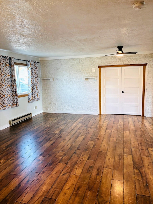 spare room featuring a textured ceiling, a baseboard heating unit, ceiling fan, and hardwood / wood-style floors