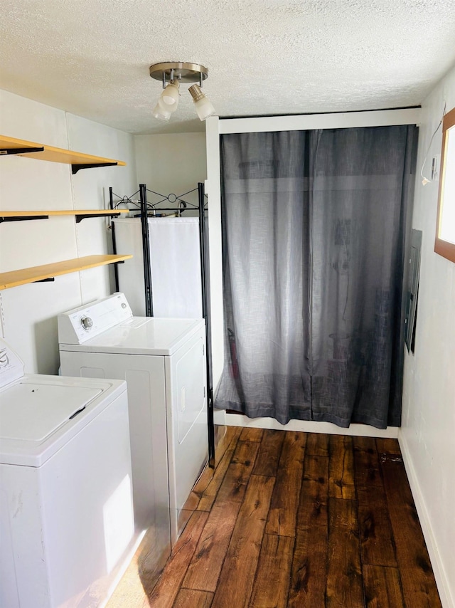 washroom with wood-type flooring, separate washer and dryer, laundry area, and a textured ceiling