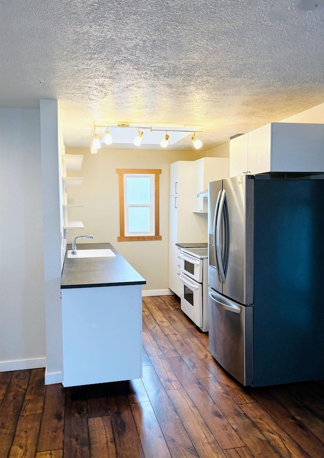 kitchen with a sink, double oven range, stainless steel refrigerator with ice dispenser, white cabinets, and dark wood-style flooring