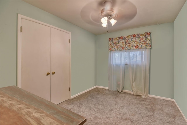 unfurnished bedroom featuring a ceiling fan, light colored carpet, baseboards, and a closet