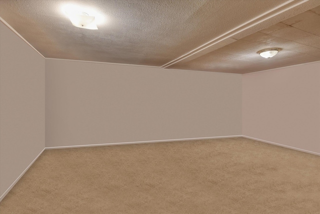 spare room featuring baseboards, carpet floors, and a textured ceiling