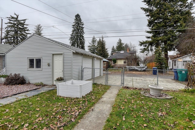 view of yard with an outdoor structure, a gate, fence, and a garage