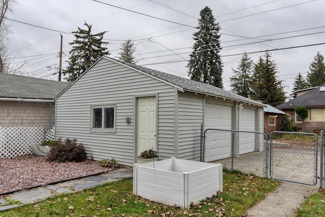 view of outbuilding featuring fence, an outdoor structure, and a gate