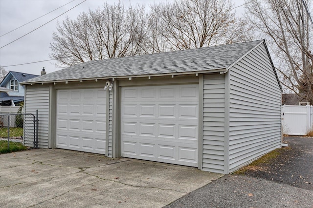 detached garage featuring fence