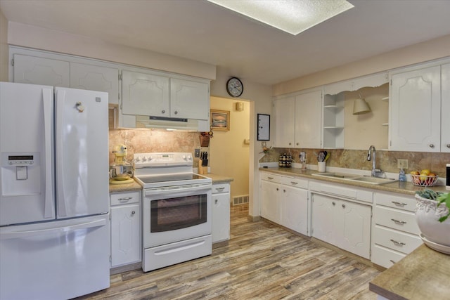 kitchen with white appliances, visible vents, a sink, white cabinets, and under cabinet range hood