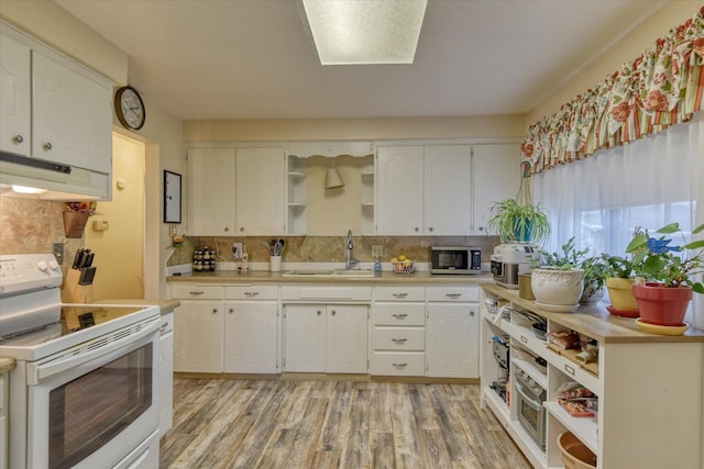 kitchen with electric stove, a sink, stainless steel microwave, open shelves, and under cabinet range hood