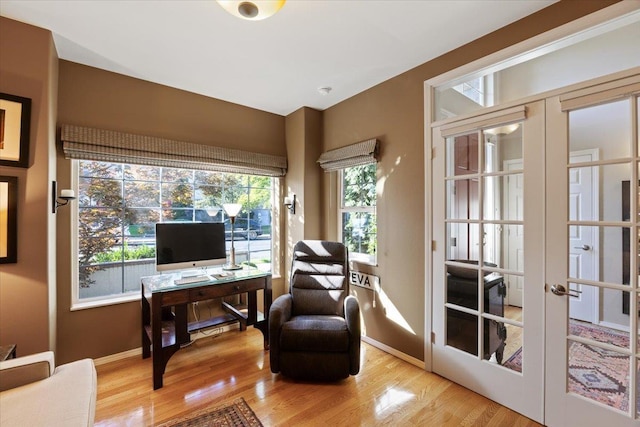 office space with french doors, baseboards, and light wood finished floors