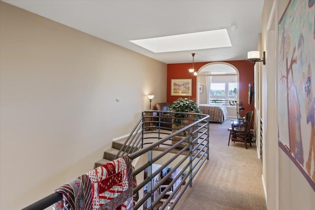 stairway featuring baseboards, carpet, and a skylight