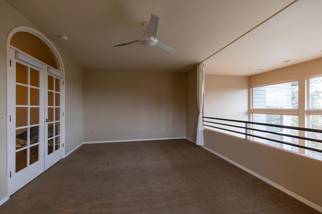 carpeted empty room with french doors, baseboards, and ceiling fan