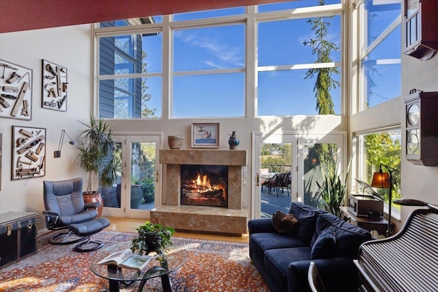 living area featuring a high ceiling, wood finished floors, and a premium fireplace