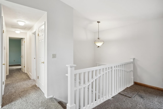 hall with baseboards, carpet floors, attic access, and an upstairs landing