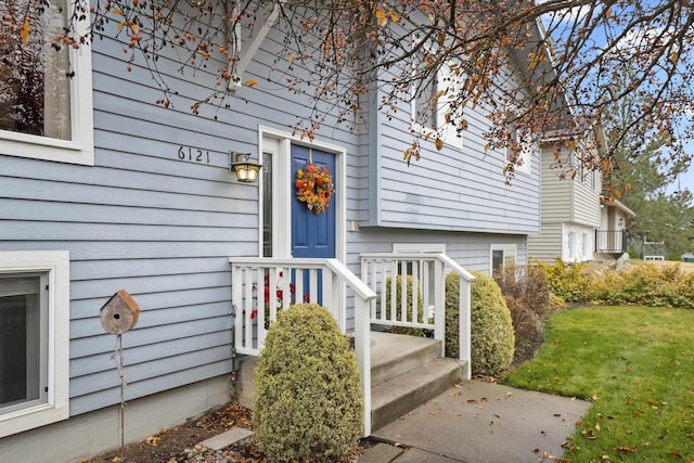 property entrance featuring a lawn