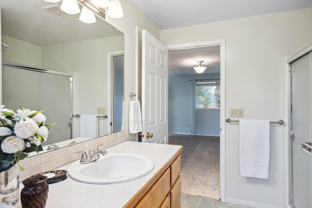 full bath with an enclosed shower, baseboards, visible vents, and vanity