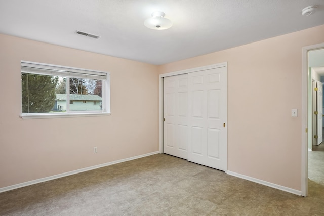 unfurnished bedroom with baseboards, visible vents, and a closet