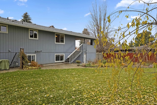 back of house with fence, a lawn, stairs, and a patio area