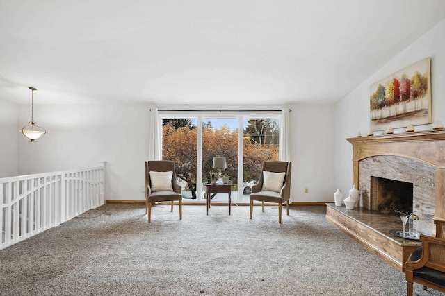 living area with a high end fireplace, baseboards, and carpet