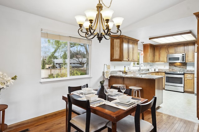 dining area with a chandelier and light wood-type flooring