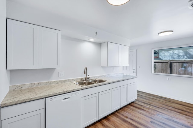 kitchen with a sink, light countertops, white cabinets, dishwasher, and light wood-type flooring