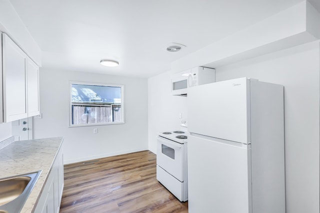 kitchen featuring light wood-type flooring, visible vents, white appliances, white cabinets, and light countertops