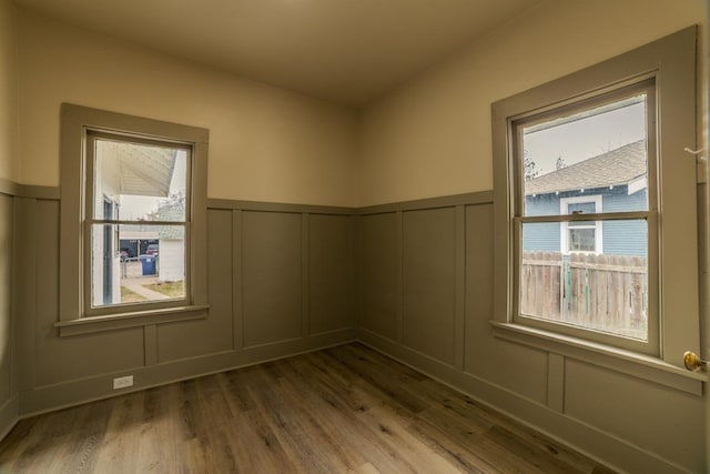 spare room with a decorative wall and wood finished floors