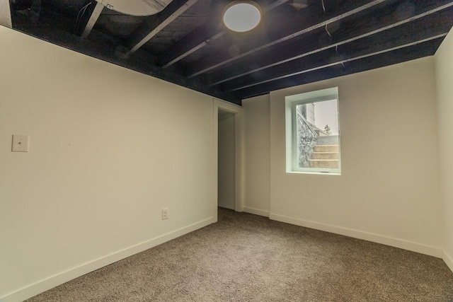 carpeted empty room featuring baseboards