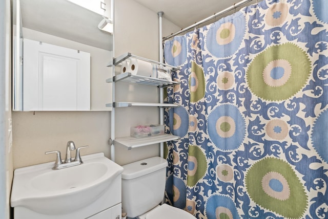 bathroom with curtained shower, toilet, and vanity