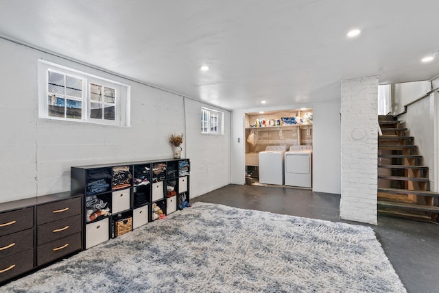 below grade area featuring recessed lighting, concrete block wall, stairs, and washer and clothes dryer